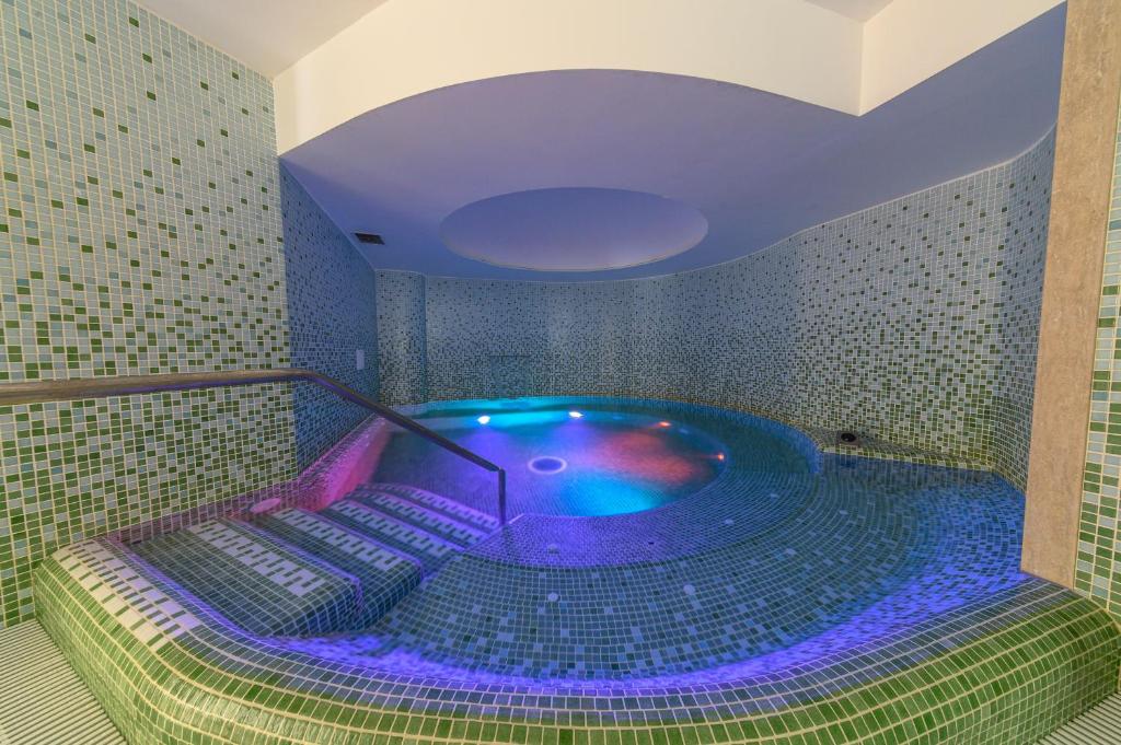a jacuzzi tub in a bathroom with purple lighting at Oriente Suites e Spa in Ischia