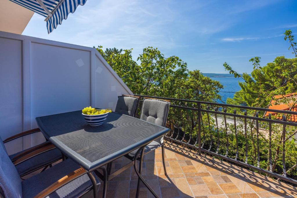 uma varanda com uma mesa e vista para o oceano em Apartmani Azur em Dramalj