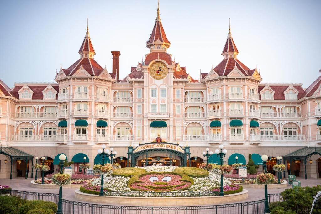 un grand bâtiment avec une grande horloge devant lui dans l'établissement Disneyland® Hotel, à Chessy