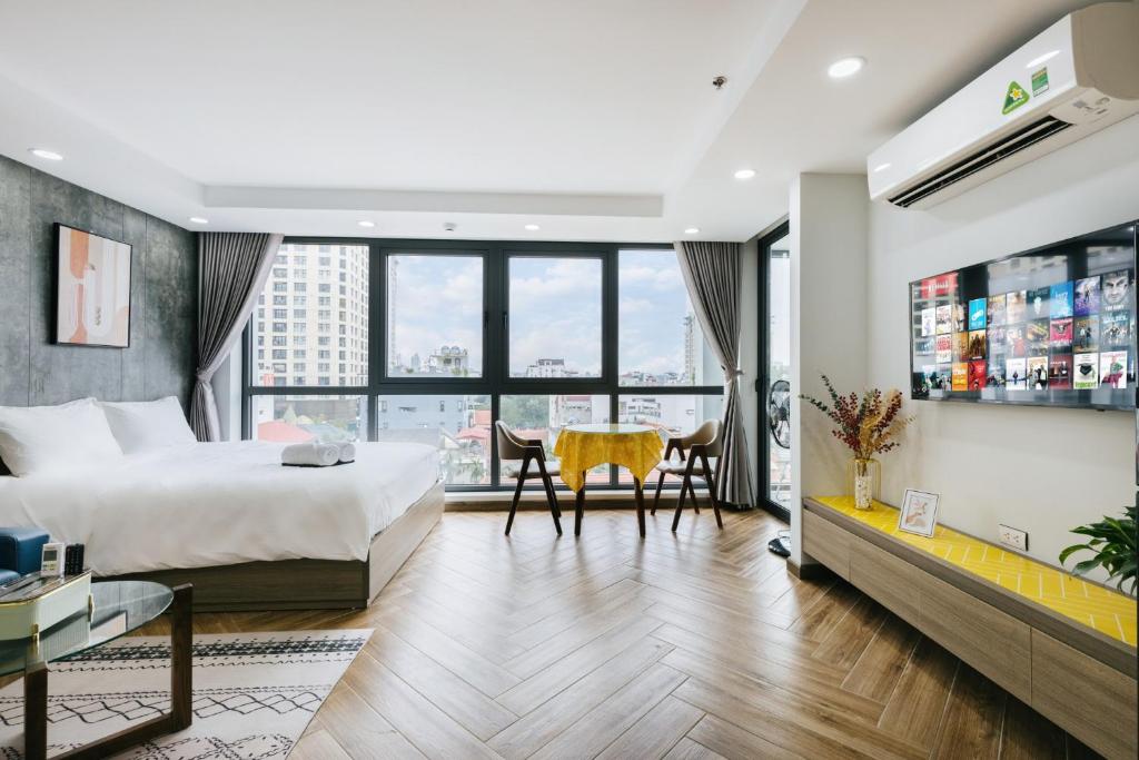 Habitación de hotel con cama, escritorio y mesa. en Westlake Emerald Suites en Hanói