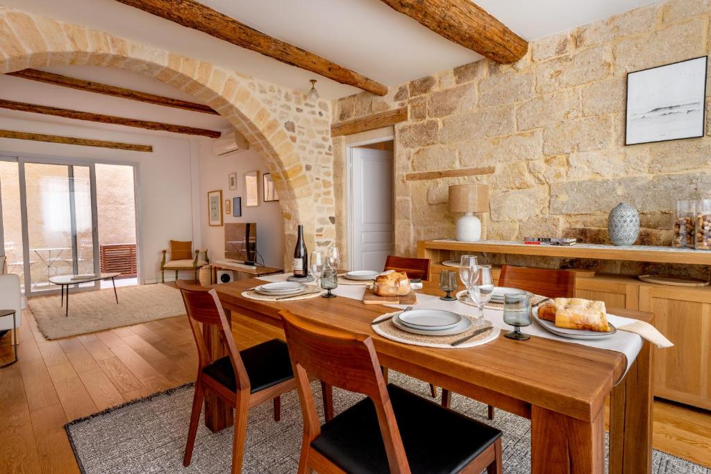 Il dispose d'une cuisine et d'un salon avec une table et des chaises en bois. dans l'établissement Les Voûtes Centre historique de Montpellier, à Montpellier
