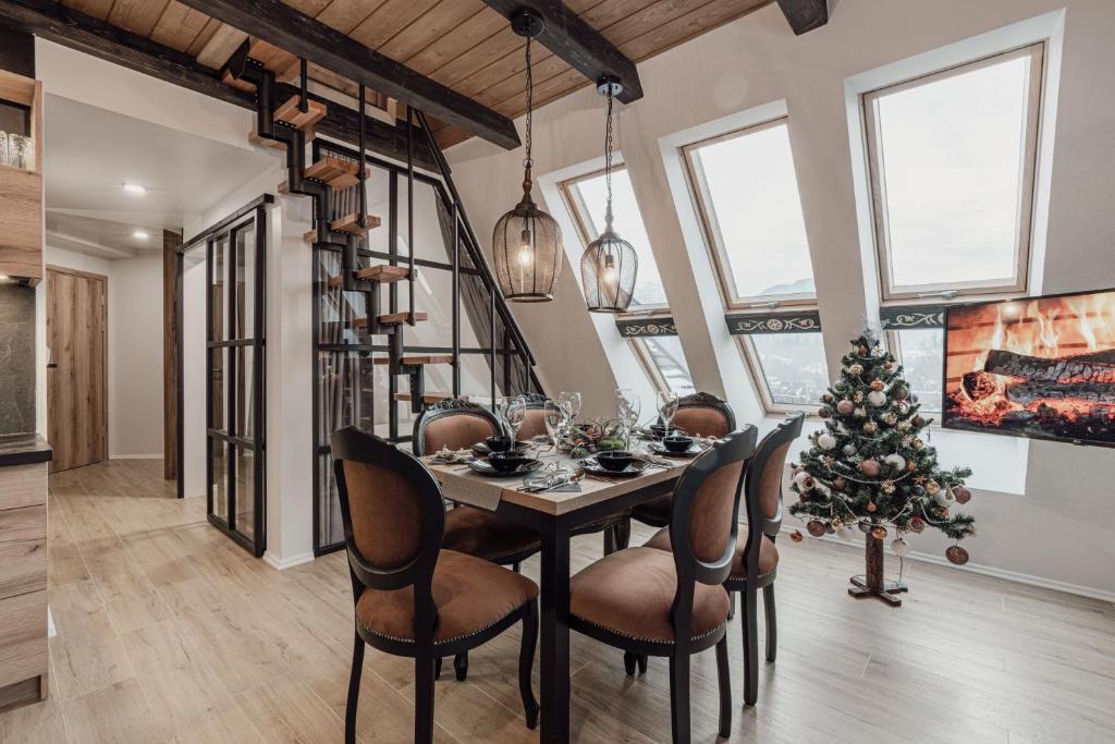a dining room with a table and a christmas tree at Góralska Prowincja in Kościelisko