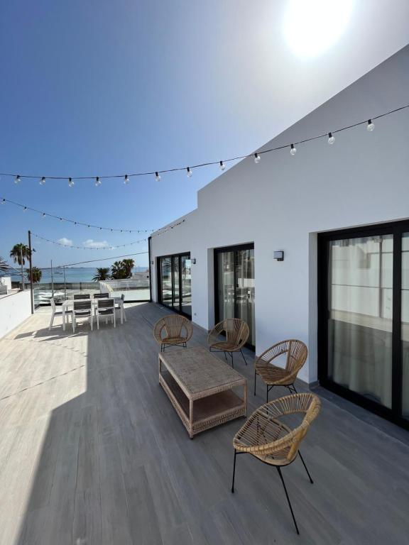 an open deck with chairs and a table at Arena Sunrise - Sea View and Main Street in Corralejo