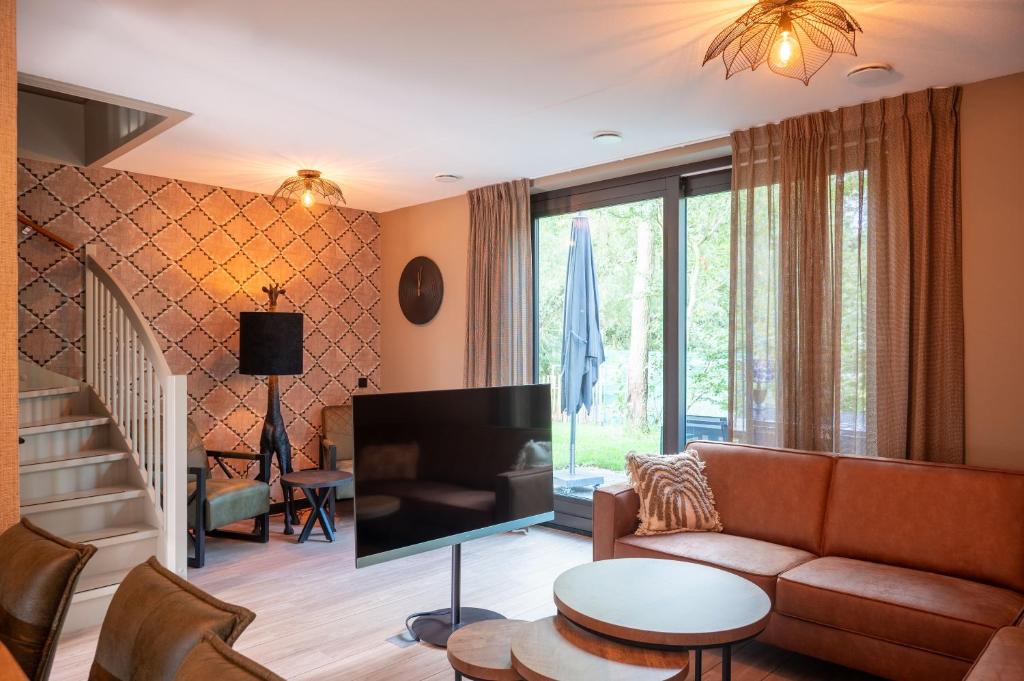 a living room with a couch and a tv at Parc La Dune South Africa Lodge in Warmenhuizen