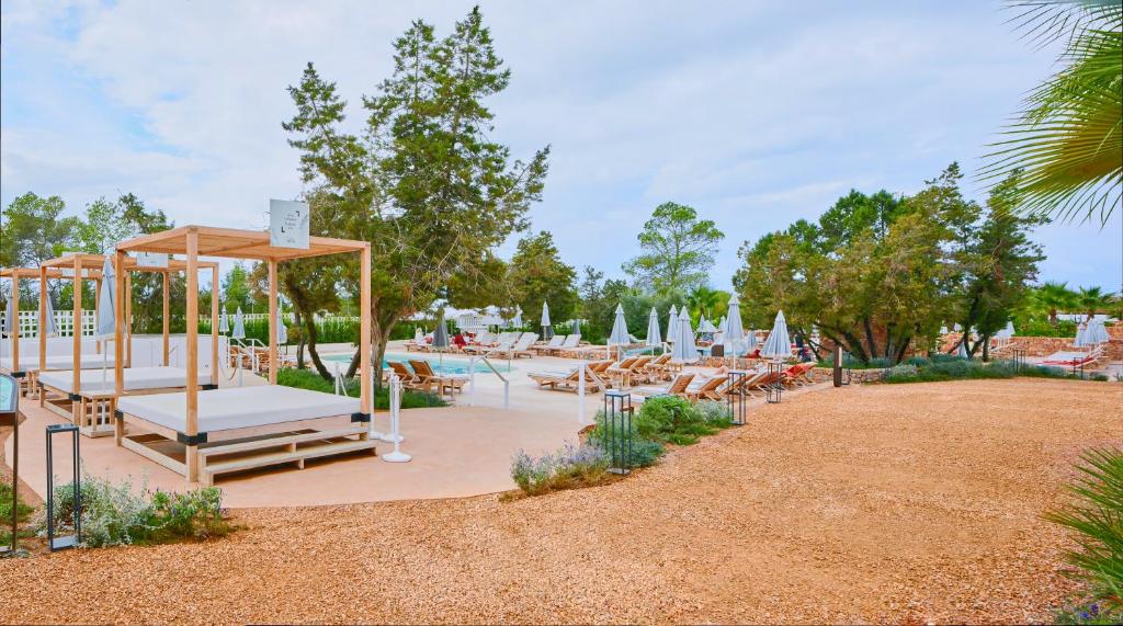 a resort with a pool with lounge chairs and umbrellas at The Signature Level at TRS Ibiza Hotel - All Inclusive Adults Only - Entrance to Clubs included in San Antonio