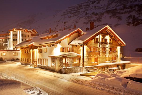 une grande maison en bois avec de la neige au-dessus dans l'établissement Bentleys House MOUNTAIN Residence, à Zürs