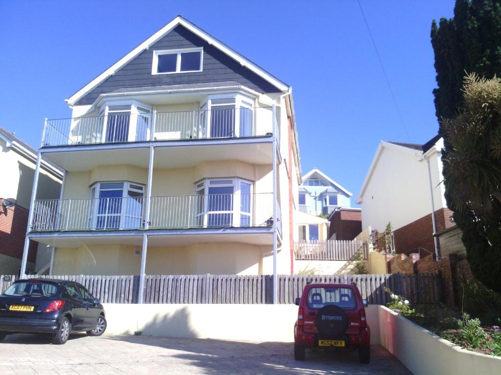 a house with two cars parked in front of it at Yew Tree House in Paignton