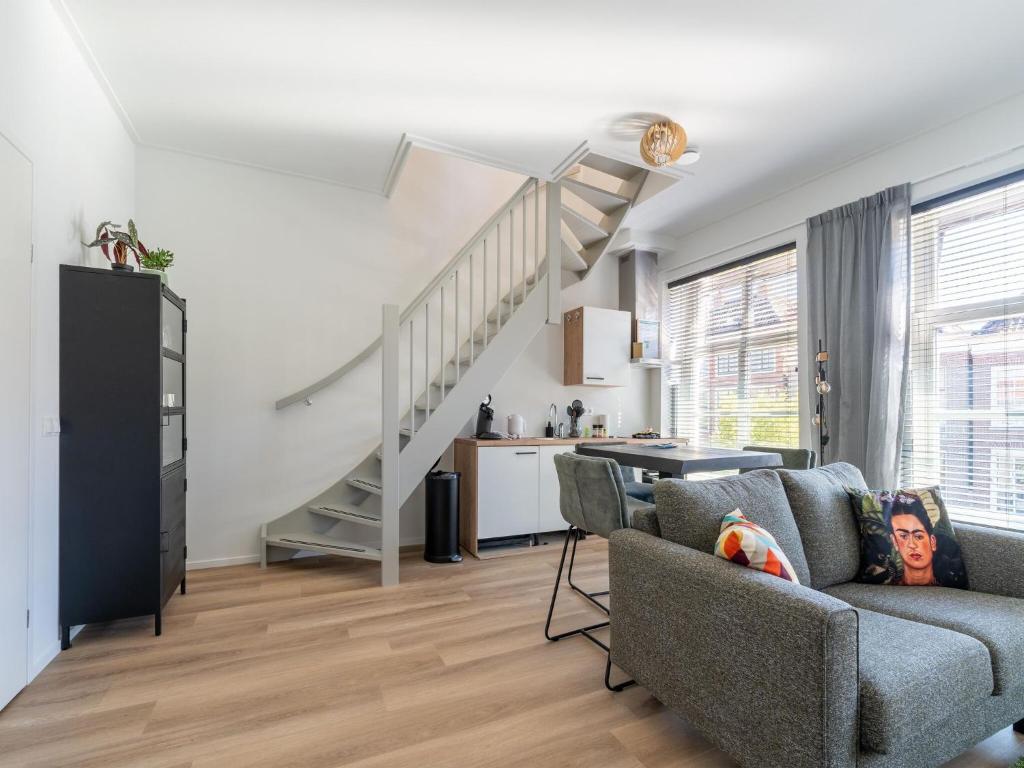 een woonkamer met een bank en een trap bij 2 modern renovated apartments in the heart of Sneek in Sneek