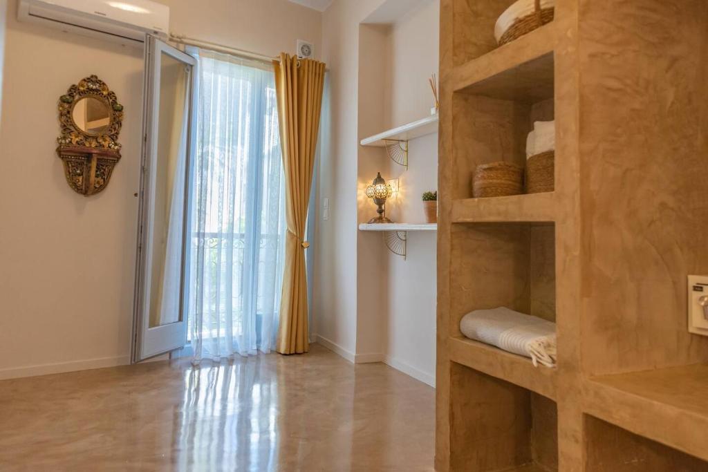 a room with a book shelf and a large window at Manus Dei Exclusive Suites in Pythagoreio