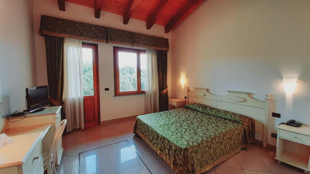 pokój hotelowy z łóżkiem i telewizorem w obiekcie Sa Rocca Sport e Resort w mieście Guspini