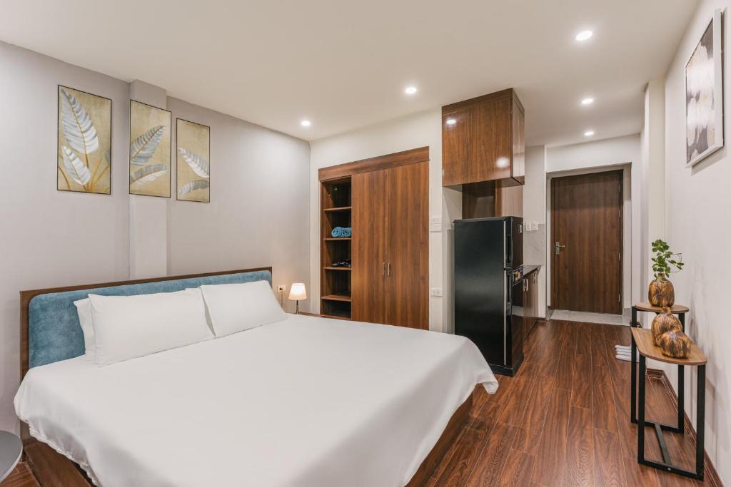 a bedroom with a large white bed and a refrigerator at Ann's Home in Hanoi