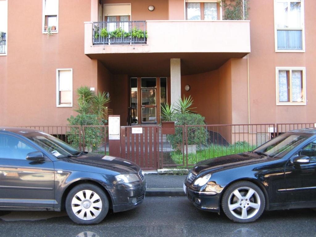 two cars parked in a parking lot in front of a building at appartamento vicino al centro in Verona