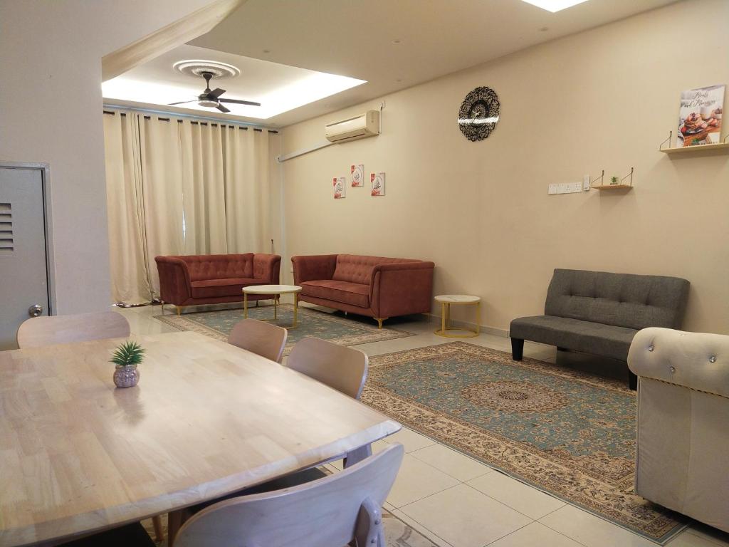 a room with a table and chairs and a couch at Axaida Homestay Parit Jawa in Bakar Parit