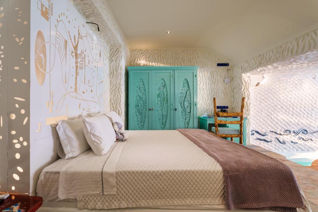 a bedroom with a bed with a green door at Agalia Luxury Suites in Tzamaria