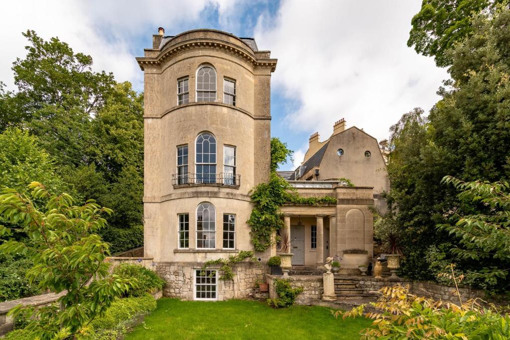an old stone house with a tower on a lawn at Somerset House Apartment - Charming Period 1BD in Bath