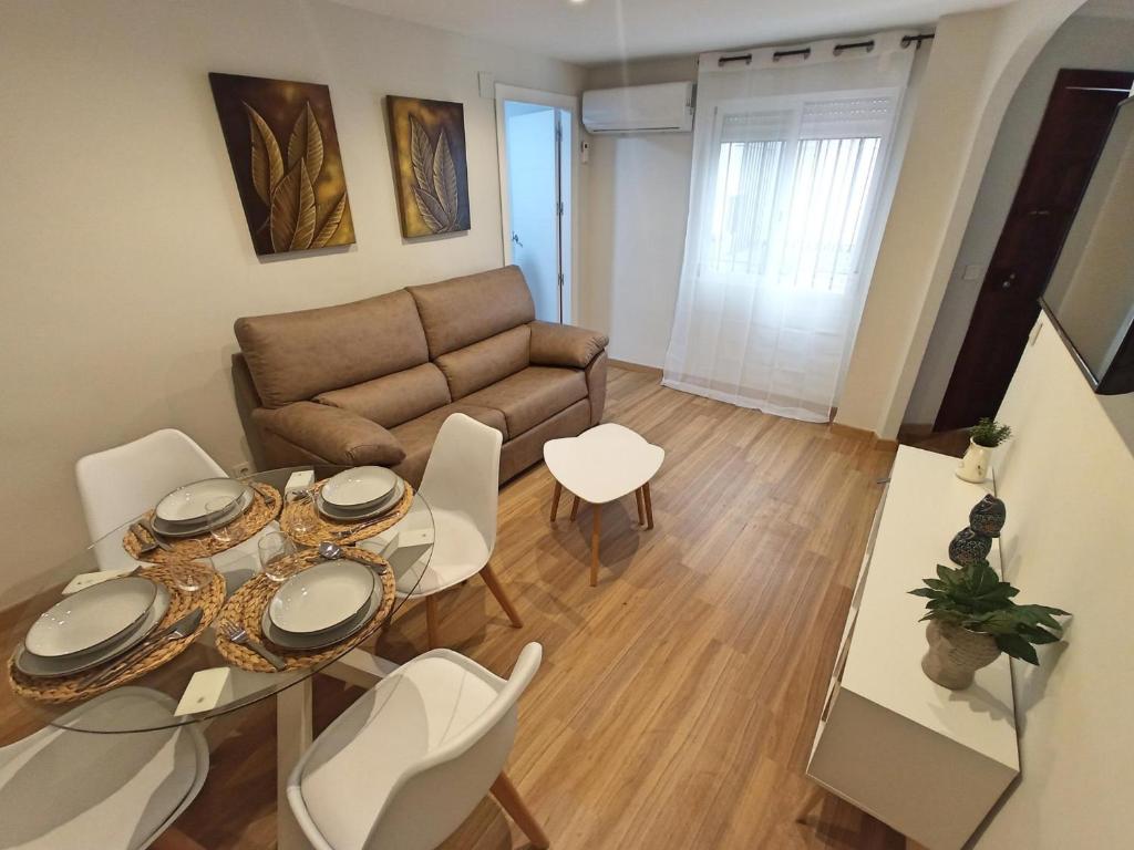 sala de estar con sofá, mesa y sillas en Apartamento DON MANUEL, en Córdoba