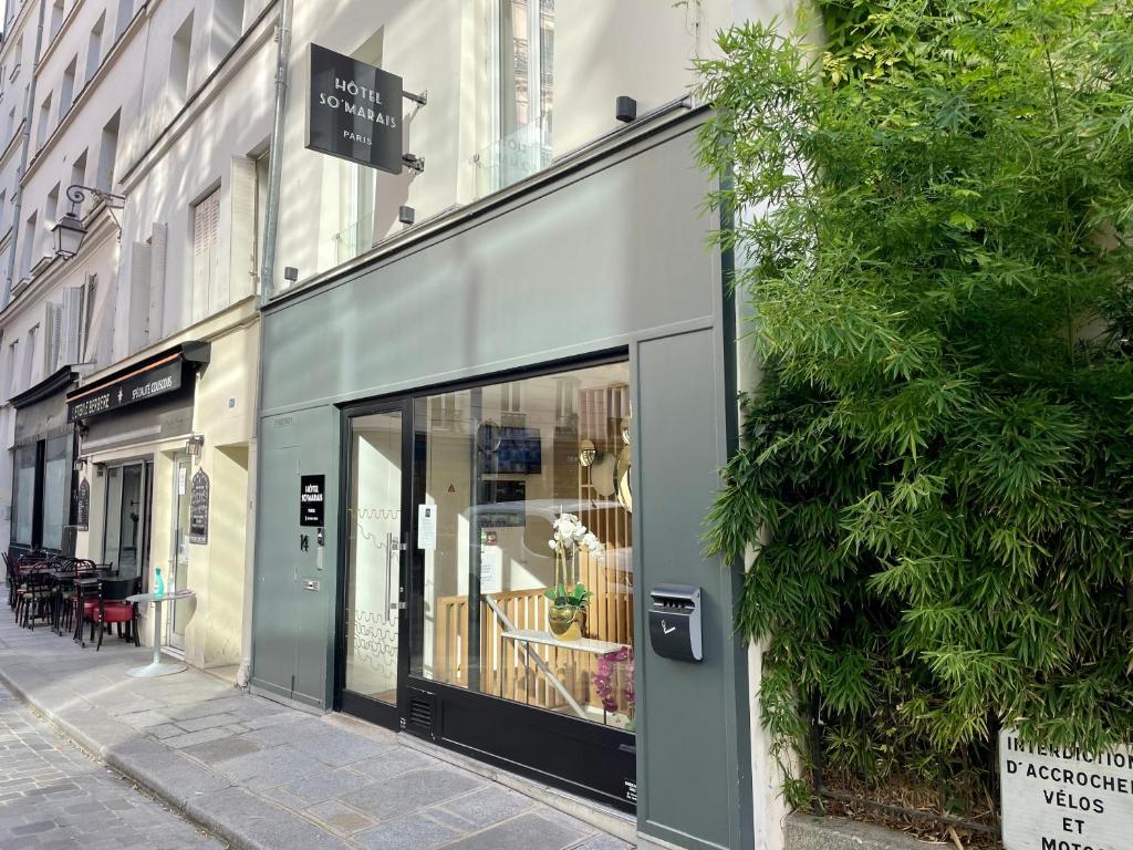 przednia część sklepu ze szklanymi drzwiami na ulicy w obiekcie Hôtel So Marais w Paryżu