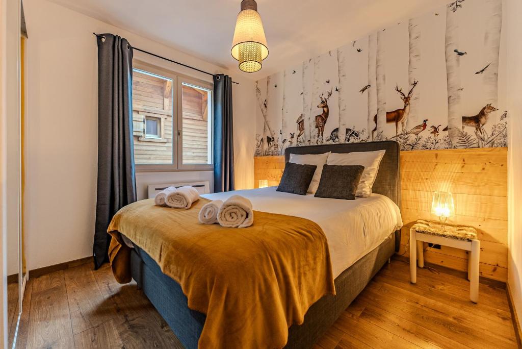 ein Schlafzimmer mit einem Bett mit Handtüchern darauf in der Unterkunft Appartement La Terrasse de Roma - LES GETS, en plein centre et au pied des pistes in Les Gets