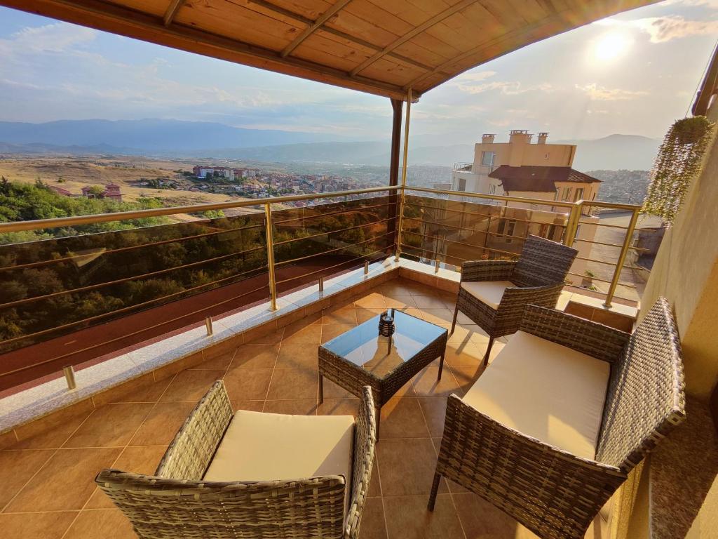 a balcony with chairs and a table with a view at Panorama view apartment in Sandanski