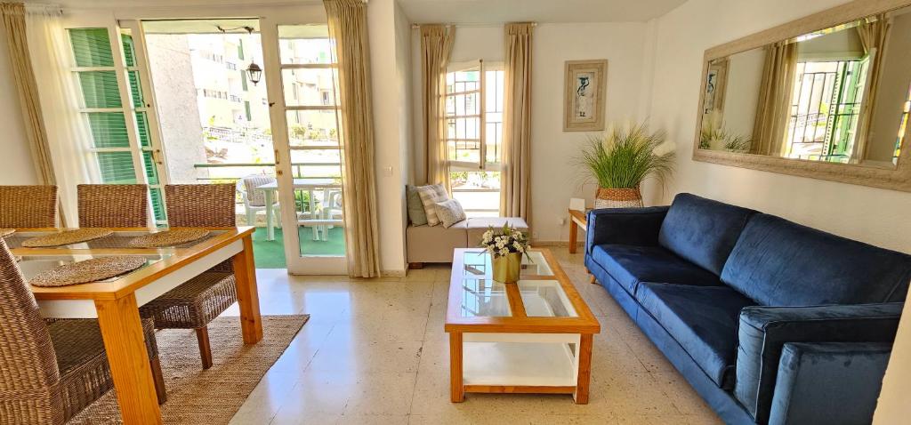 uma sala de estar com um sofá azul e uma mesa em Viñas by Villas Rinamar em Playa de las Americas