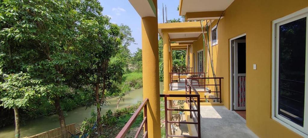 einen Balkon mit Flussblick in der Unterkunft Bardia Jungle Cottage in Bardiyā