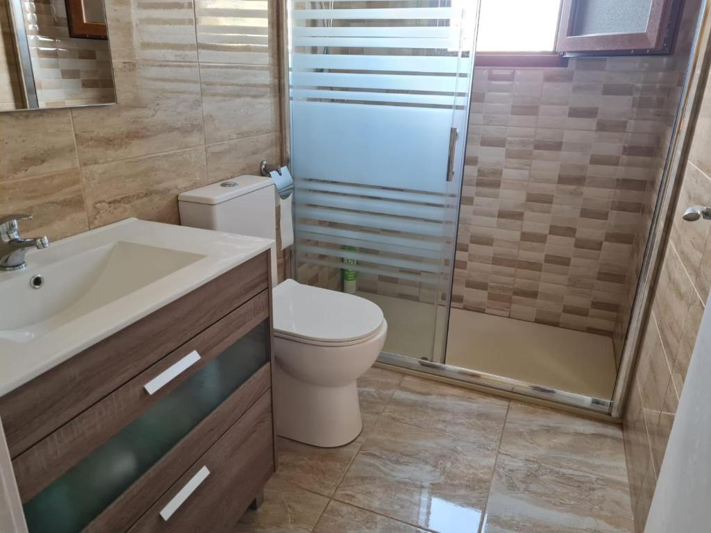 a bathroom with a toilet and a sink and a shower at Chalet Adosado Unifamiiar Rocasol Beach Torrevieja in Torrevieja