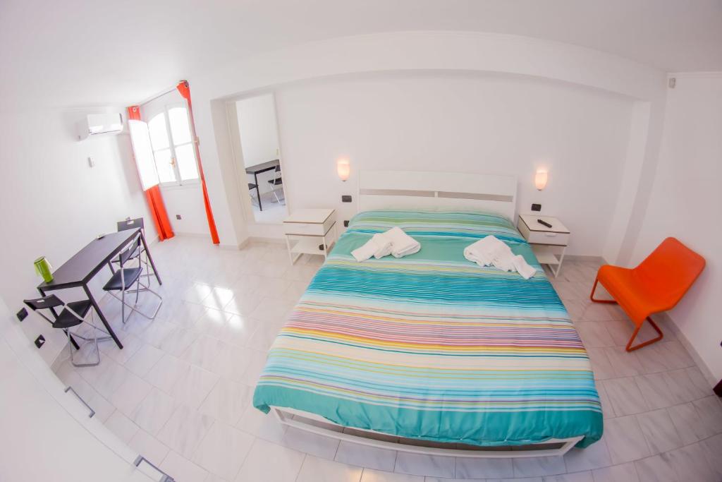 a bedroom with a large bed with a colorful striped blanket at Siculandia Residence in Mazara del Vallo