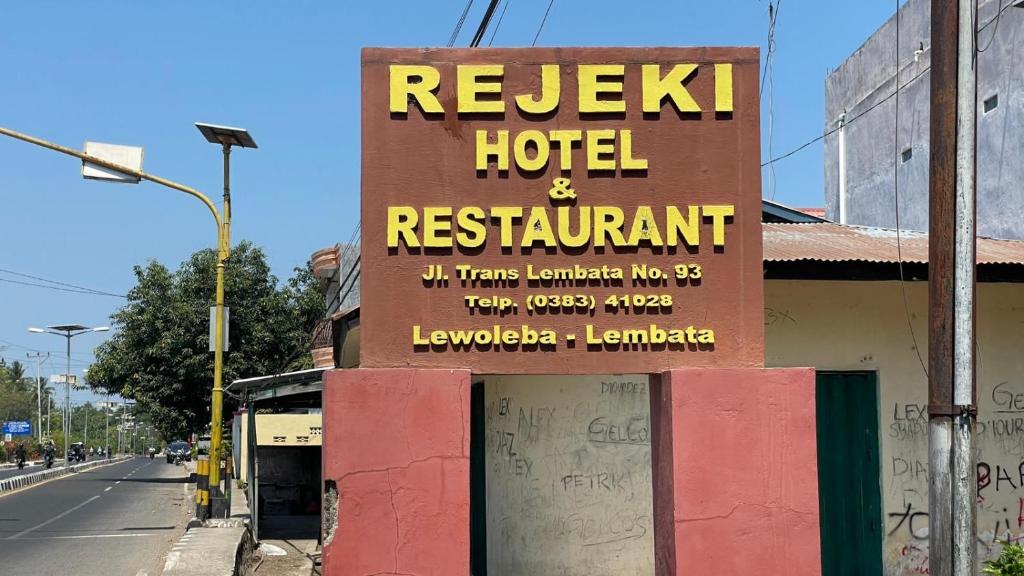 een bord voor een hotel en restaurant in een straat bij Hotel Rejeki in Lewoleba