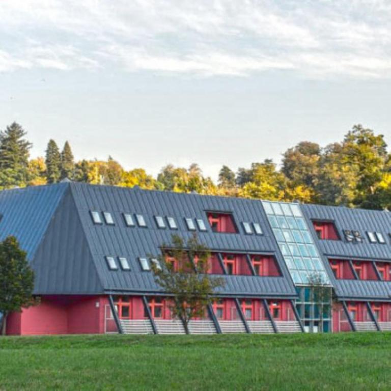 un edificio rojo con techo negro y ventanas rojas en Hotel Belaria Resort, en Opava