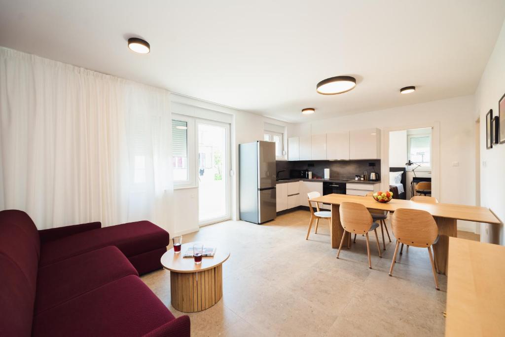 Split Luxury Suite 2 في سبليت: غرفة معيشة مع أريكة وطاولة ومطبخ