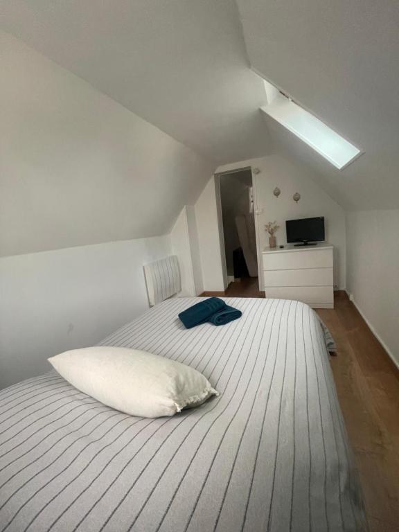 - une chambre dotée d'un lit blanc avec un oreiller dans l'établissement Petit maison avec terrasse proche de Rouen 1h30 de Paris, à Bihorel