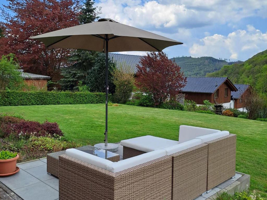a patio with an umbrella and a white couch and an umbrella at Ferienwohnung Fischer in Heringhausen