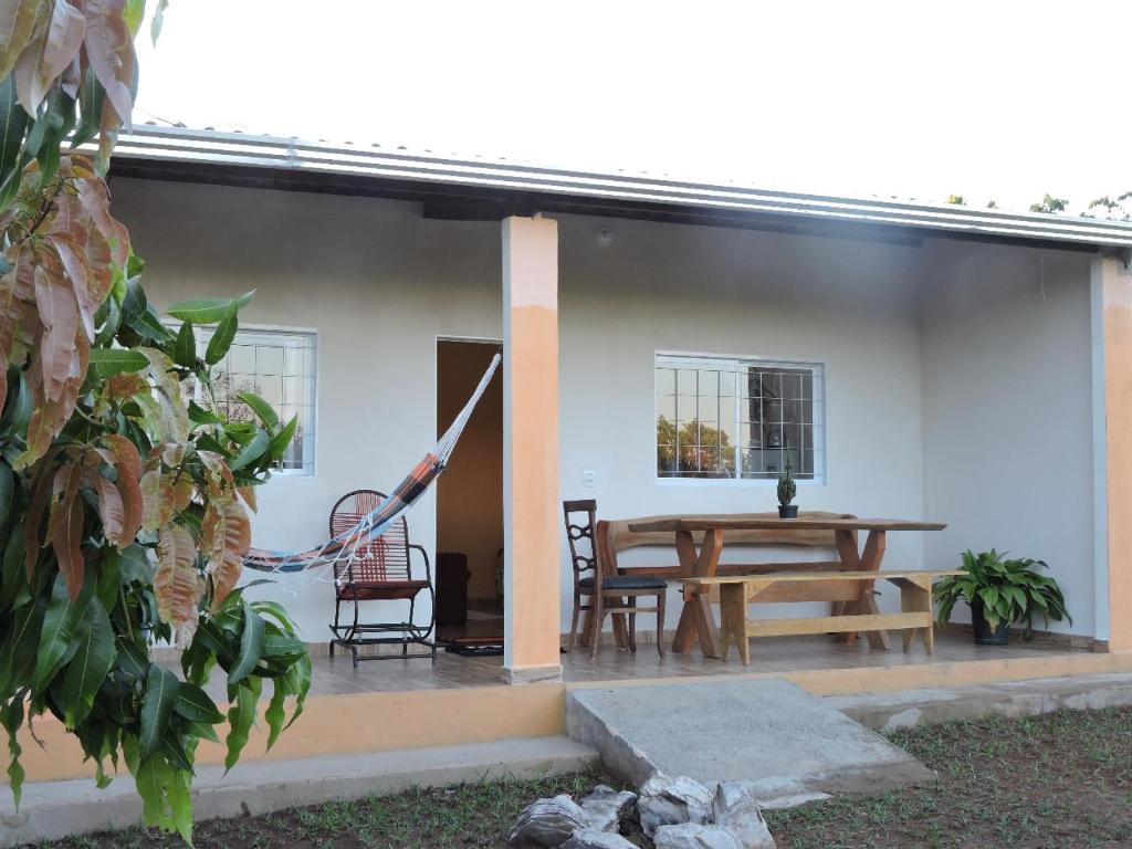 a patio with a table and chairs and a house at Casa de Campo Chalé Saturno in Alto Paraíso de Goiás