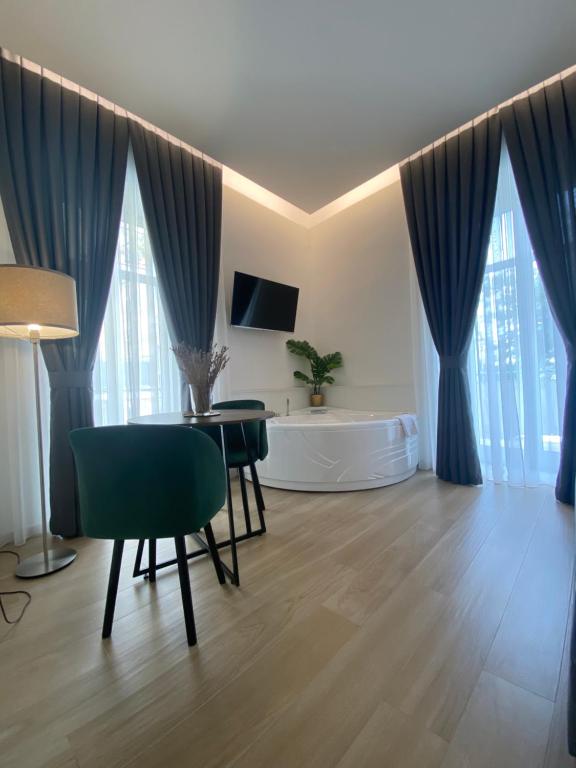 un soggiorno con tende blu, tavolo e sedie di GUALTIERI B&b - LUXURY ROOMS a San Giorgio a Cremano