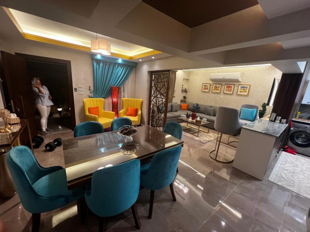 een woonkamer met een tafel en blauwe stoelen bij luxury flat with garden and private entrance شقة فاخرة بحديقة و مدخل خاص in Caïro