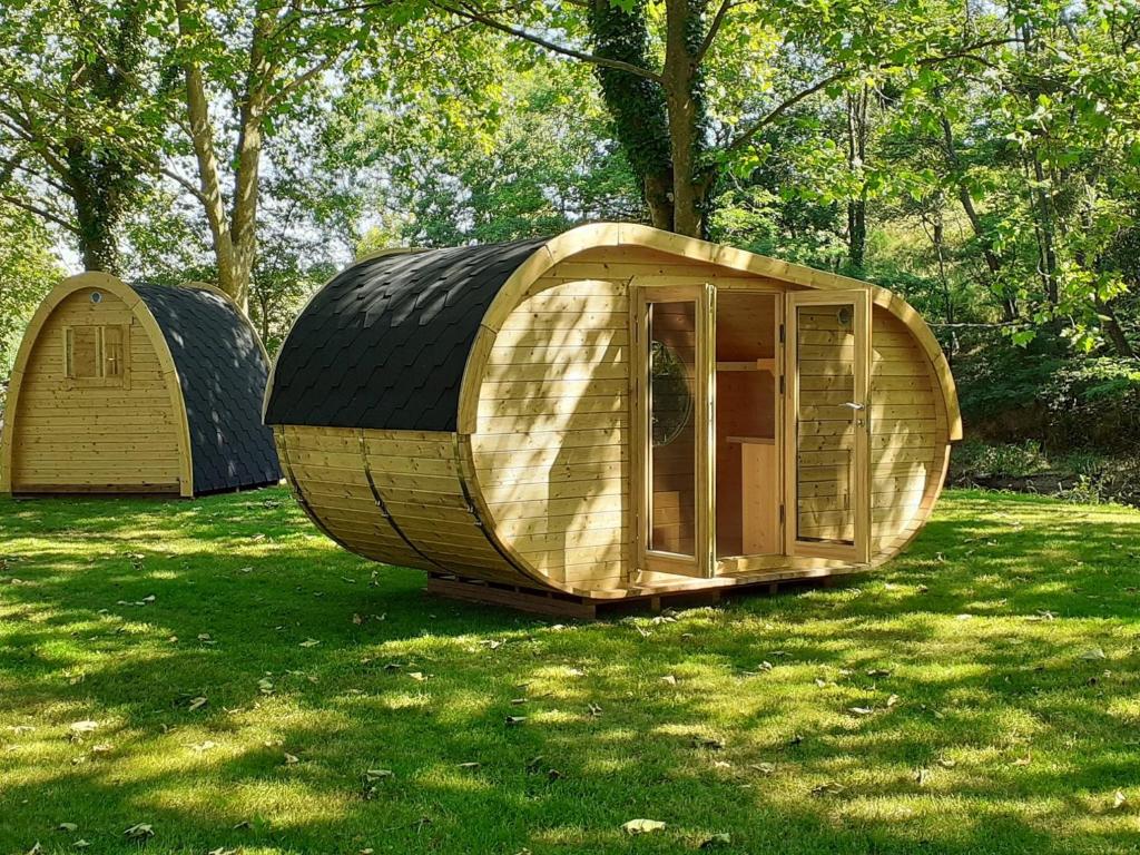 a couple of small wooden houses sitting in the grass at Camping de la Bageasse in Brioude