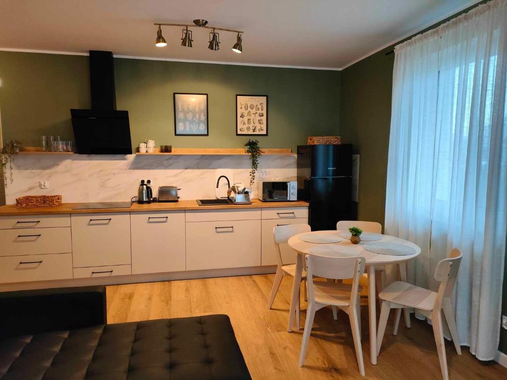 uma cozinha com uma mesa e uma pequena mesa e cadeiras em Apartament Margarita em Kudowa-Zdrój