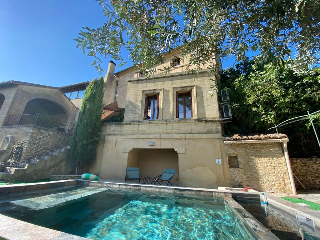 a house with a swimming pool in front of a house at Maison uzès piscine plein sud avec superbe vue in Saint-Maximin