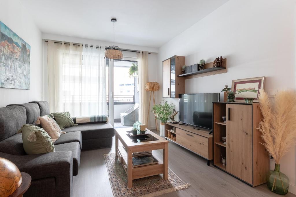 sala de estar con sofá y TV en Xirimiri apartment by People Rentals en Bilbao