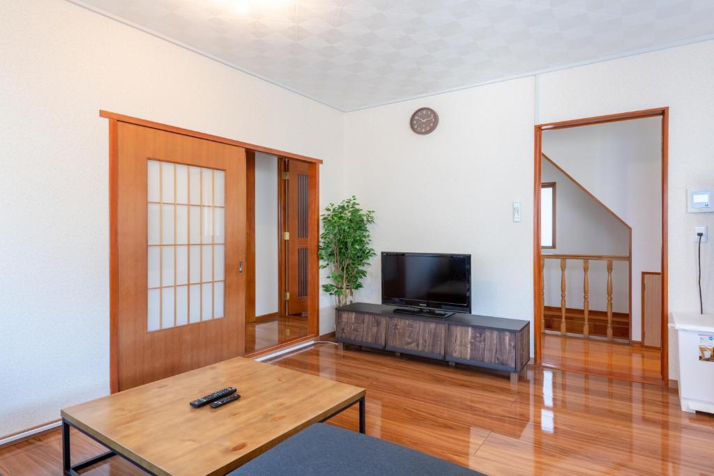 a living room with a table and a tv at 平井戸建 in Tokyo