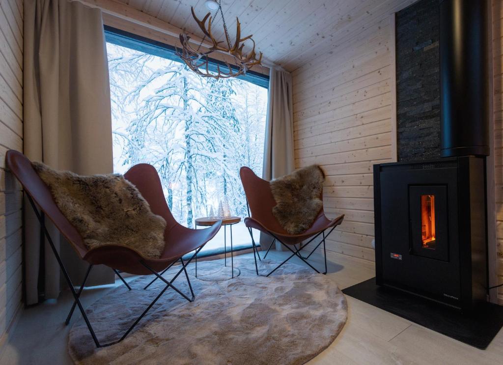 a living room with two chairs and a fireplace at Skyfire Village Igloos in Rovaniemi