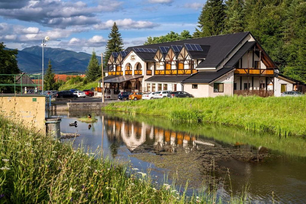 ein Haus mit einer Reflexion in einem Fluss in der Unterkunft Penzión Zivka in Závažná Poruba