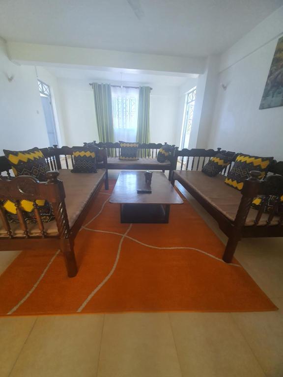 a living room with couches and a table at Emily Apartments Kisumu on Hatupe Enterprises Ltd Building in Kibos