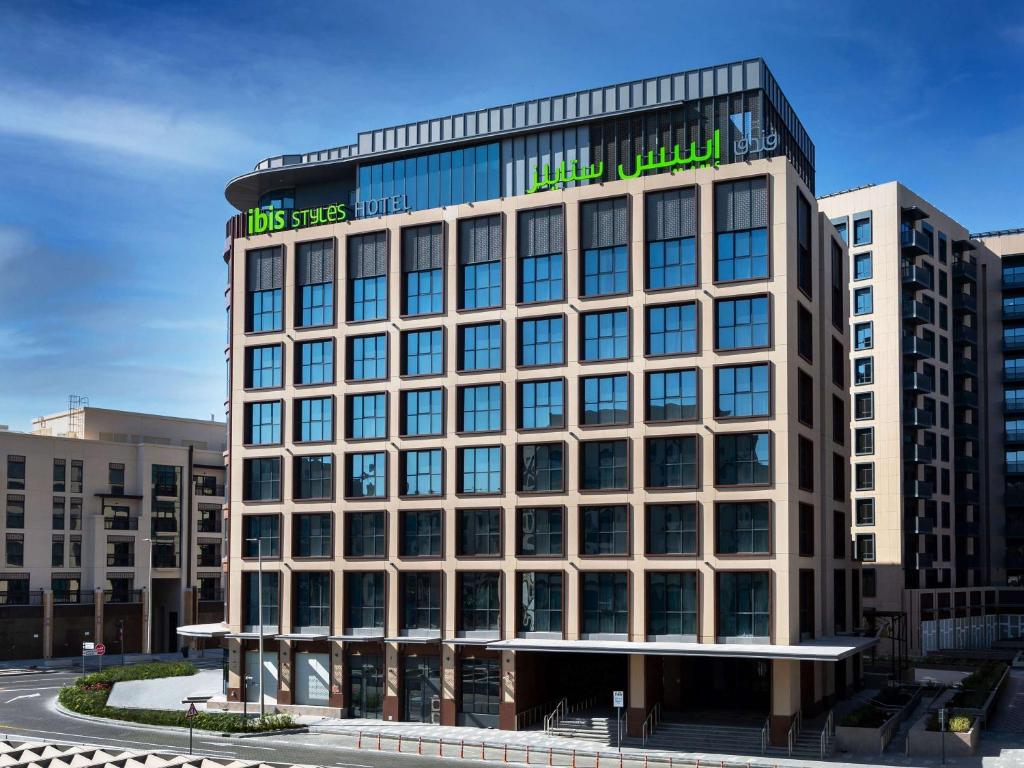 a large building with a sign on top of it at ibis Styles Dubai Deira in Dubai