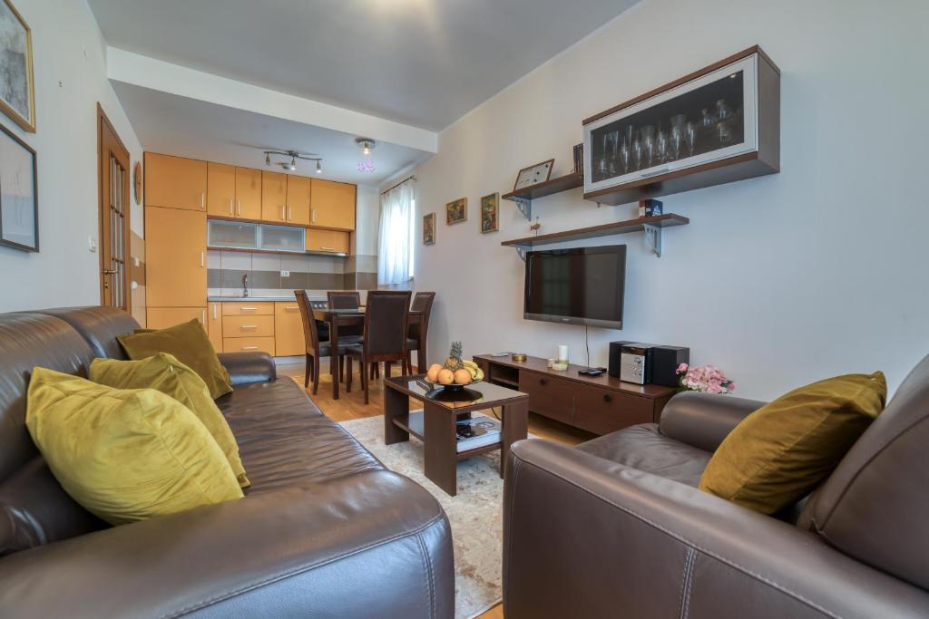 uma sala de estar com um sofá e uma mesa em Gold apartman em Podgorica