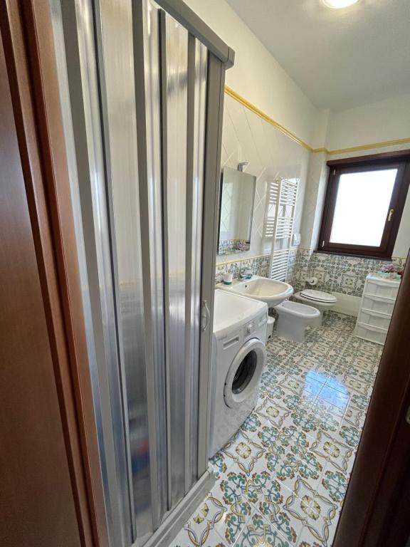 y baño con ducha y lavadora. en Luxury Apartment Vanacore, en Castelnuovo Cilento