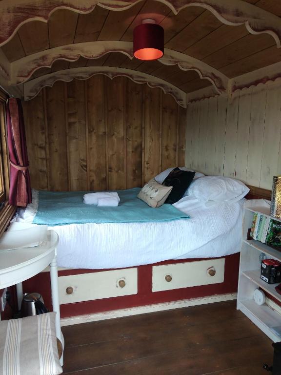a bedroom with a bed in a wooden room at Shirehill Farm, Shires Barns in Chippenham