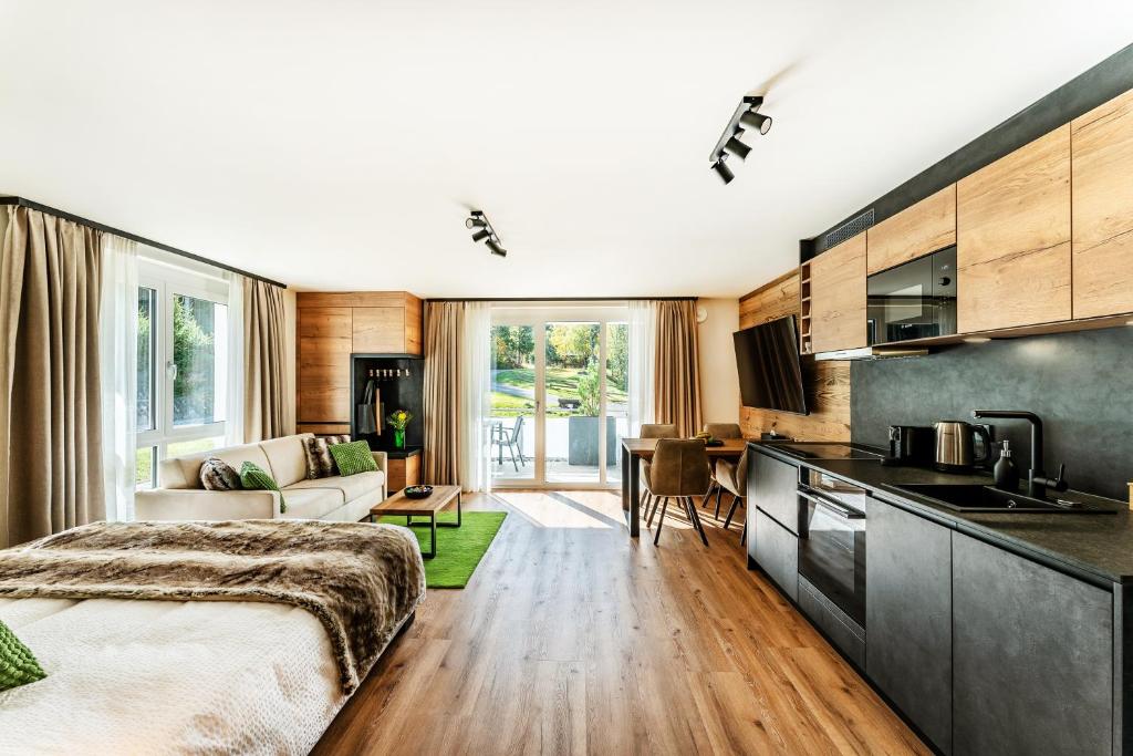 um quarto com uma cama, uma cozinha e uma sala de estar em Black Forest Luxury Apartment Bärenhöhle mit Sauna em Schluchsee