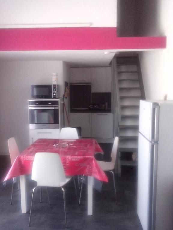 une cuisine avec une table, des chaises et un tissu de table rouge dans l'établissement Marendes Des Palombes 2, au Barcarès