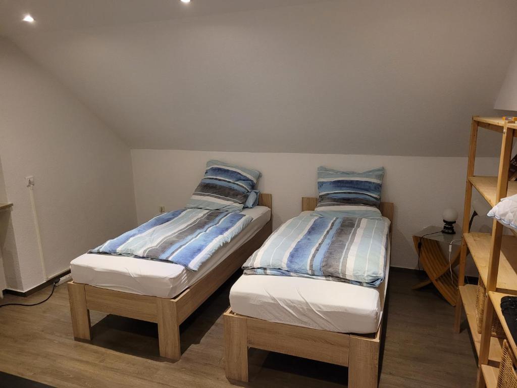 Duas camas individuais num quarto com prateleiras de madeira em Gästezimmer em Springe